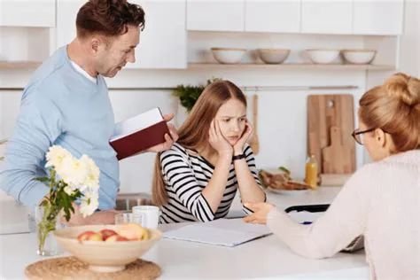 Vader en moeder helpen een gefrustreerd meisje met haar huiswerk aan de keukentafel