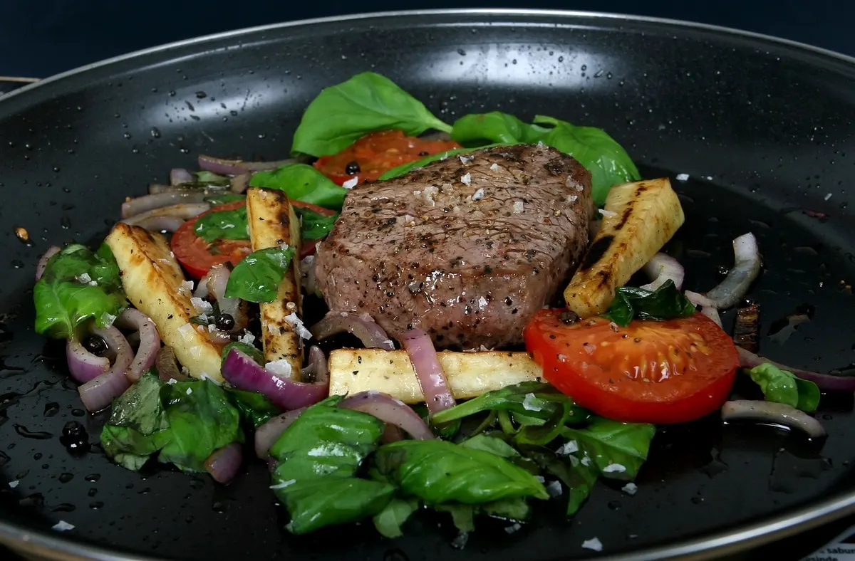 Biefstuk met gegrilde groenten, tomaat en spinazie in een pan