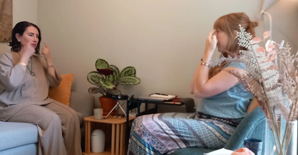 Therapeut en cliënte tappen samen op EFT-punten tijdens een sessie in de praktijk