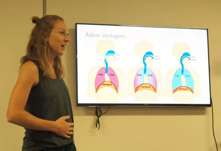 Ademcoach geeft uitleg over rustig ademhalen bij een scherm met longen en middenrif