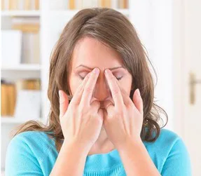 Vrouw tapt met haar vingertoppen op het EFT-punt aan het begin van de wenkbrauwen